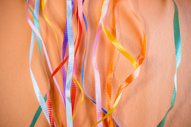 Loose ribbons are aranged on colourful paper for an abstract fusion of colours.