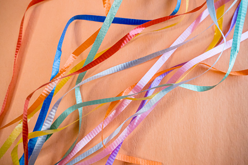 Loose ribbons are aranged on colourful paper for an abstract fusion of colours.