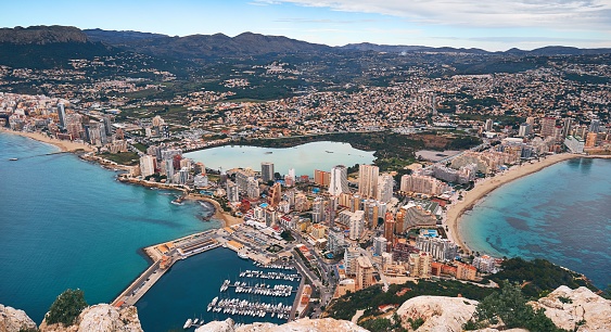 Aerial drone view from of Penon de Ifach rock on picturesque view  bay of Mediterranean Sea, mountain range, cityscape scenery,  Costa Blanca, Spain