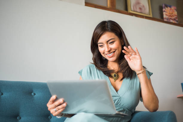 istock Latina woman greets on video call at home. Copy space 1454696509