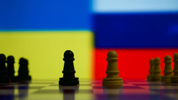 istock Chess pieces in front of the Ukrainian and Russian flags 1454705656