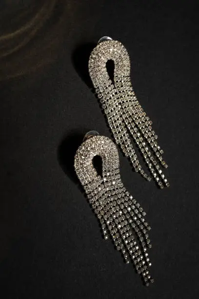 Long dangling rhinestone earrings, on a black paper background