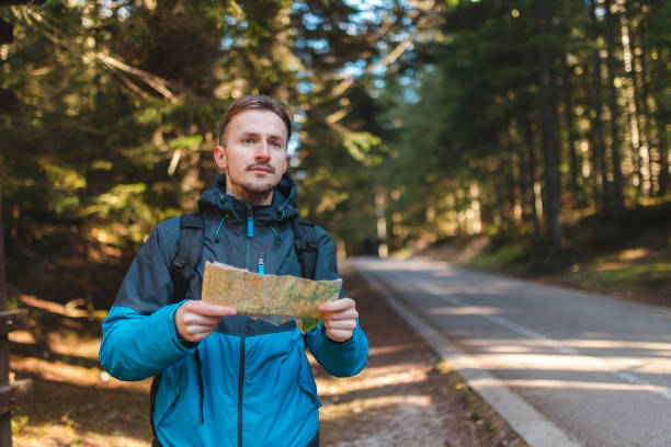 istock Young male hiker lost in the woods holding a map 1454708547
