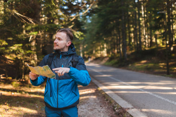 istock Handsome young hiker looking at the map outdoors in the forest 1454708561
