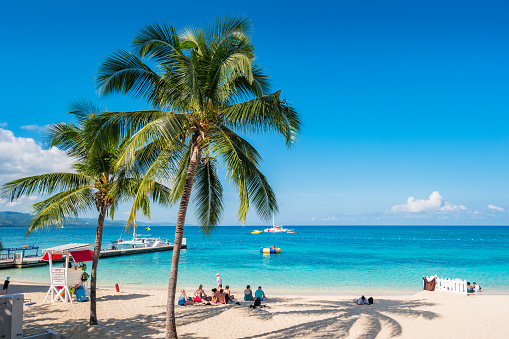 People enjoy Doctor's Cave Beach in Montego Bay Jamaica on a sunny day.