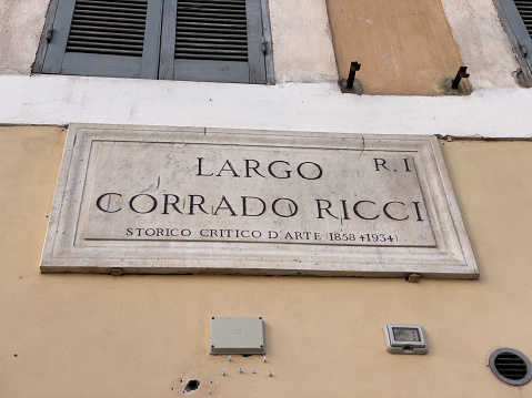 Marble street sign on a building wall in Rome: \