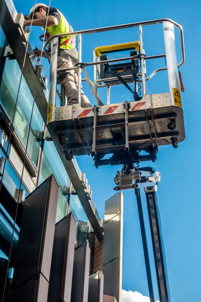 Workman hoisted using a mechanical crane to a high level stock photo