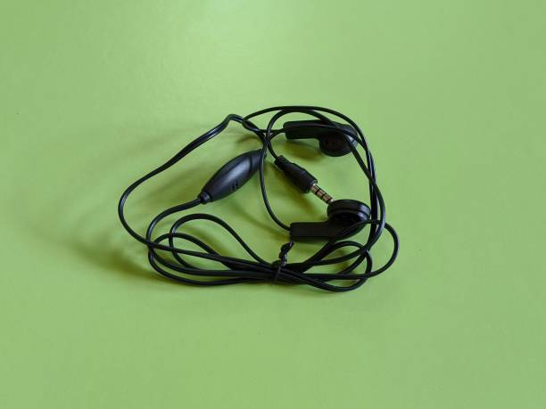 istock Black earphone on green background 1454734524