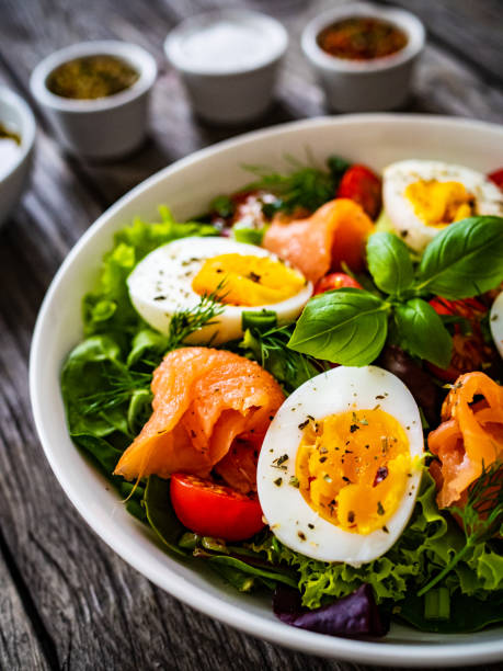 istock Smoked salmon with boiled eggs and leafy vegetables on wooden table 1454741188