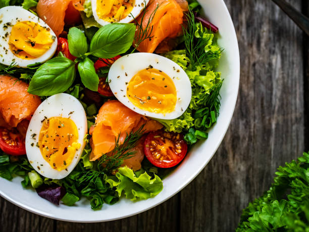 istock Smoked salmon with boiled eggs and leafy vegetables on wooden table 1454741211