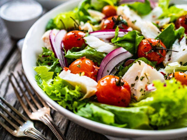 gebratener fisch- und gemüsesalat auf holzgrund - salat stock-fotos und bilder