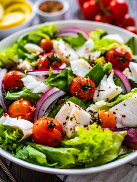 istock Roast fish and vegetable salad  on wooden background 1454741381