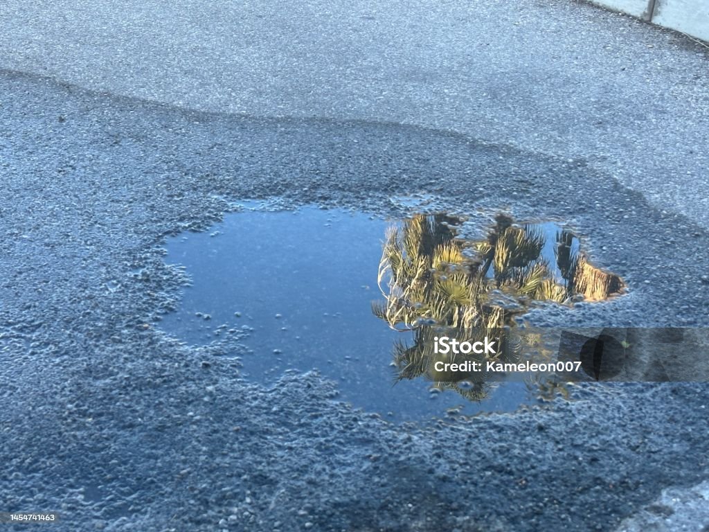Pothole in parking lot Puddle Stock Photo