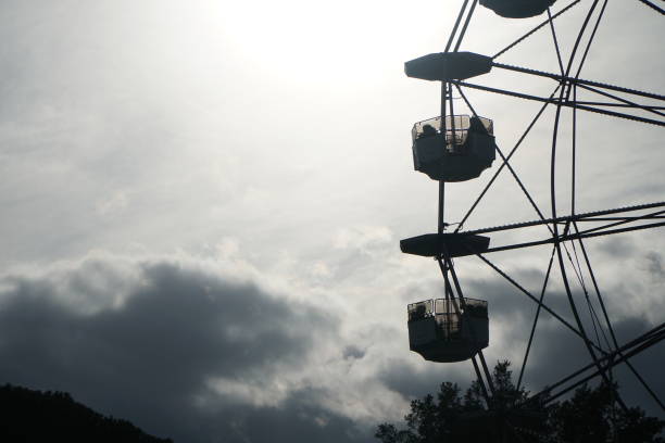 istock Silohuette Ferris wheel in backlight on cloudy sky 1454743228