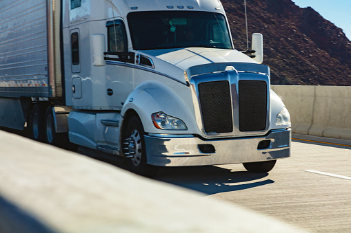 Commercial Semi Truck Cargo Transport Hauling Supplies on an Interstate Highway in the Western USA Daytime Freight and Travel Infrastructure Photo Series