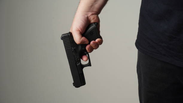 Handgun in gunman hand. A man ready to protect himself from bad people Handgun in gunman hand. A man ready to protect himself from bad people gunman stock pictures, royalty-free photos & images