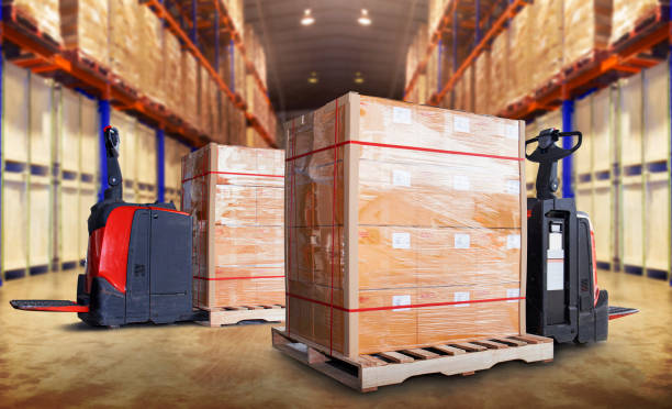 istock Electric Forklift Pallet Jack with Packaging Boxes Stacked on Pallets.  Cartons Boxes. Storage Warehouse. Supply Chain. Cargo Shipping. Supplies Warehouse Logistics. 1454749503