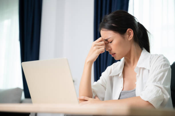 istock Office syndrome. Overworked tired young asian woman feeling headache, having eyesight problem after computer laptop work. Stressed young woman suffering from fatigue at home 1454749571