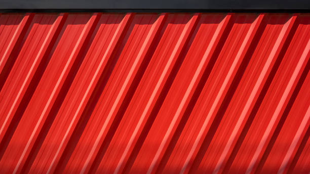 istock Sunlight and shadow on diagonal pattern of red Corrugated steel fence wall with black edge 1454752745