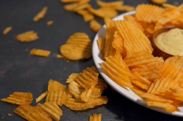 istock potato chips with cheese sauce on a white plate on a black and gray loft background 1454752931
