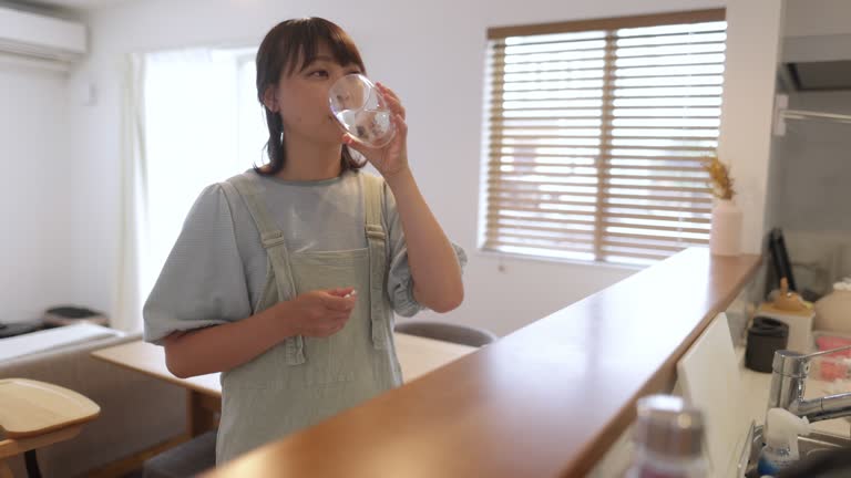 Woman taking a pill at home