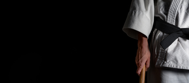 A person practicing aikido martial art on a black background.