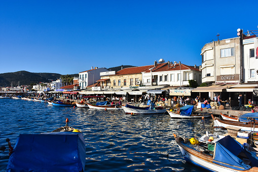 Izmir, Foca Turkey. 07.06.2021 Streets leading to the sea, fishing boats, restaurants, and nomadic people walking in Old Foça. Foca is a famous town on the Aegean coast