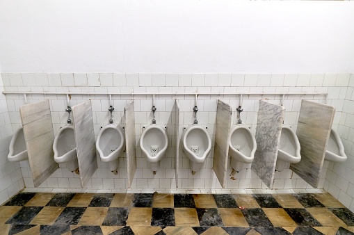 The men's room with white porcelain urinals in a row