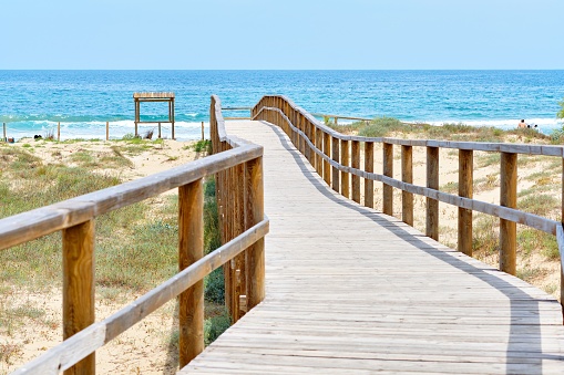 A wooden empty board walk leading through the ocean