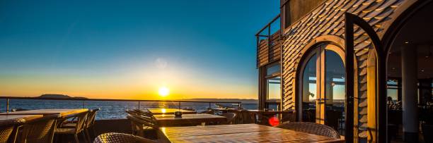 istock Terrace with tables and chairs of outdoors coastal restaurant building during 1454765982