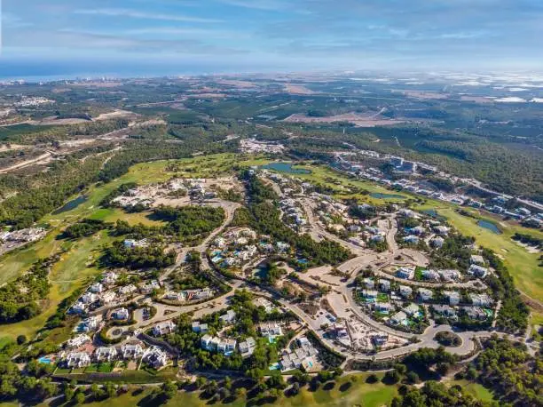 An aerial view of Spanish Las Colinas golf course with modern luxury villas and surrounding countryside