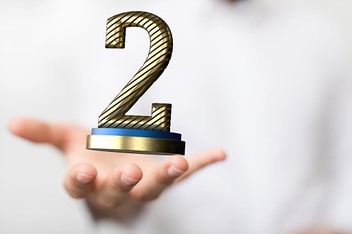 A 3D render of a number '2' prize near a hand