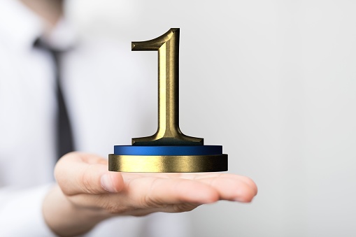 A 3D render of a number '1' prize near a hand