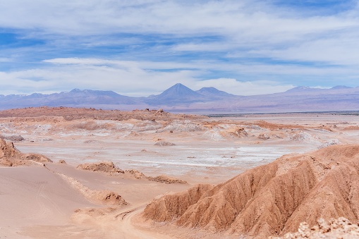 A scenic view of the Atacama desert in Chile under a cloudy blue sky