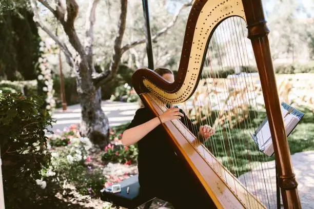 A woman playing a harp outdoors