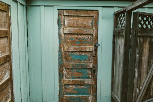 An antique wooden door with paint peeling off