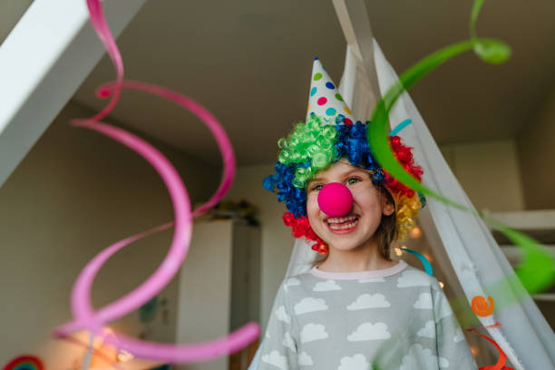 Funny clown standing with hands outstretched against white background.