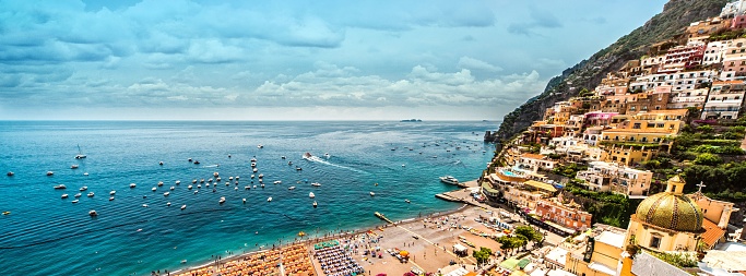 A panoramic view of the Amalfi coast with hillside houses and the Mediterranean Sea in Positano, Italy