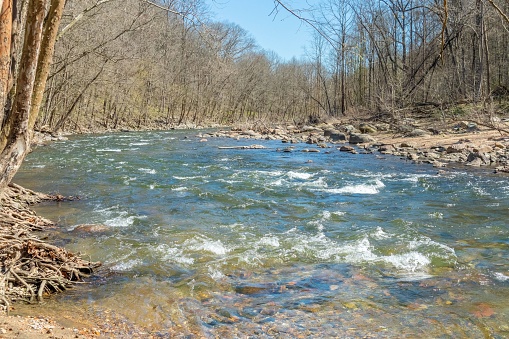 A scenic view of a river flowing over the rocks in Patapsco State Park, Baltimore, Maryland
