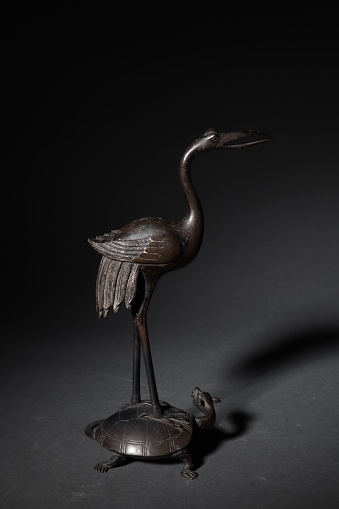 A vertical shot of an ancient Chinese bronze bird statue