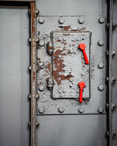 istock Industrial metal door with a red handle 1454774624