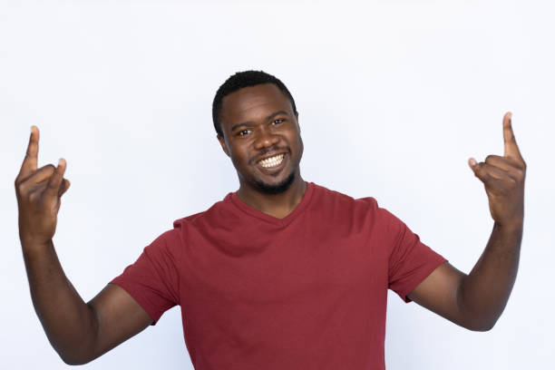 istock Cheerful young man showing rock-n-roll gesture 1454777499
