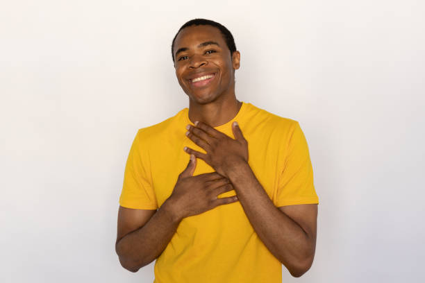 istock Pleased young man holding hands on chest hearing compliment 1454777525