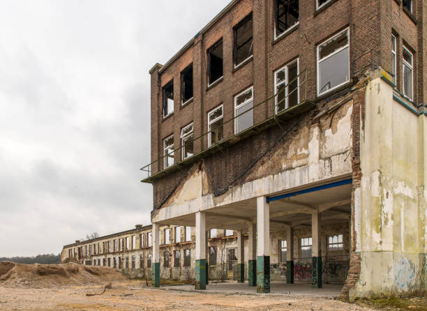istock Abandoned building with broken windows against the cloudy sky 1454777767