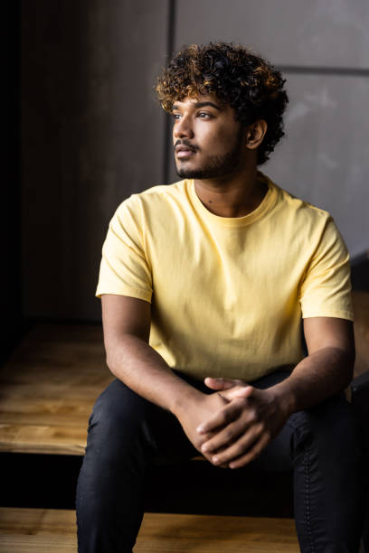 istock Low angle indian man sitting on steps at home 1454778074