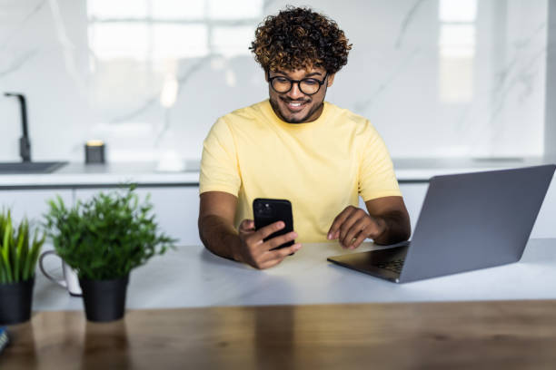 istock Indian man use notebook and phone work in the morning 1454778540