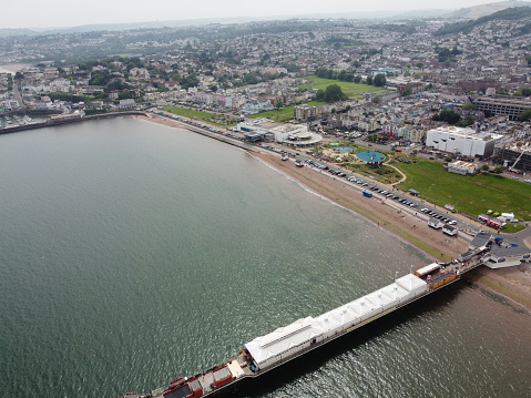 Seafront, beach and Palace Pier at Brighton in East Sussex, England. With zip wire ride and people enjoying seaside.