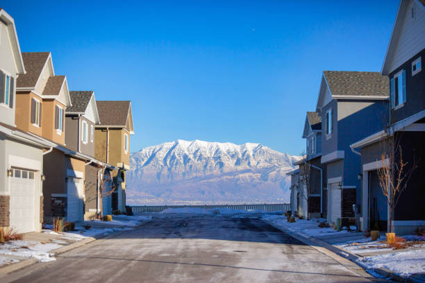 The two parallel rows of houses separated by road going to a mountain on a sunny day