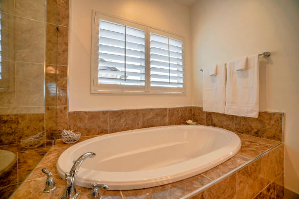 istock Bathtub in a bathroom with brown and beige tile walls 1454779879