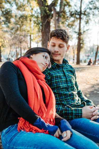 istock young couple sitting in park enjoying afternoon 1454780238